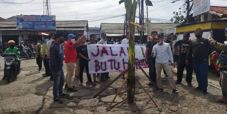 Puluhan masyarakat yang tergabung dalam Aliansi Batuceper Menggugat melakukan aksi damai dengan menanam pohon pisang di tengah Jalan Garuda, Kecamatan Batuceper, Kota Tangerang, Senin 21 Maret 2022.