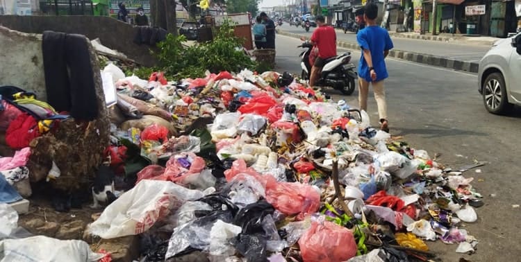 Sampah menumpuk di Jalan Maulana Hasanudin, Kecamatan Cipondoh, Kota Tangerang, Senin 11 Juli 2022. Tumpukan sampah itu nyaris menutupi setengah jalan tersebut.