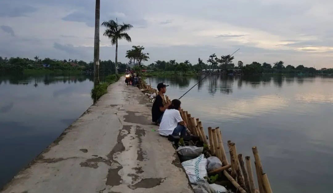 Jalan Tepi Danau Cipondoh, hidden gem Kota Tangerang yang viral di media sosial, tawarkan ketenangan dan keindahan senja di tepi danau.