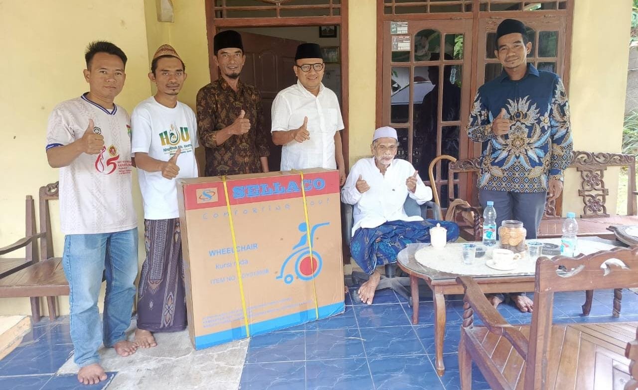 H. Ahmad Imron serahkan kursi roda untuk KH Suher di Kronjo, berkat dukungan Gubernur Andra Soni, simbol kepedulian dan harapan.